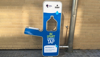 A modern water fountain with bottle-shaped filling station, cobranded Victoria University and Greater Western water